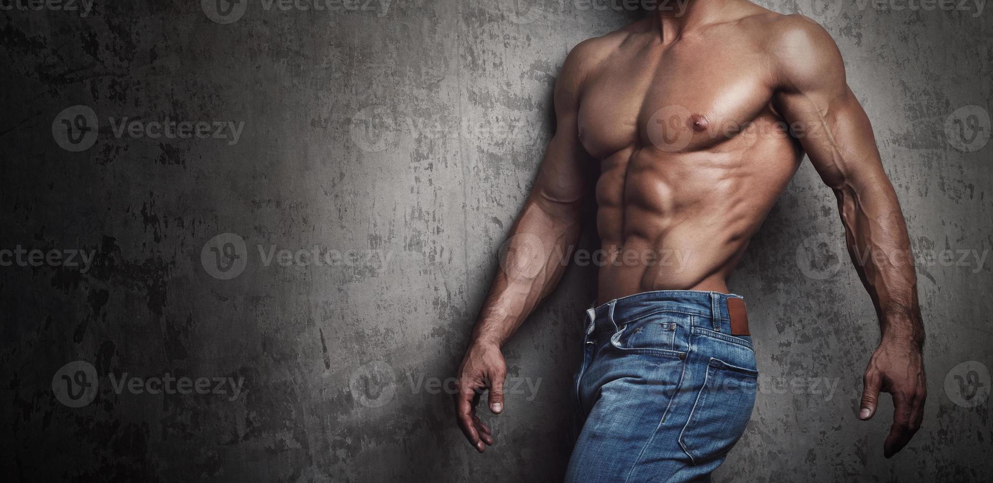 Muscular torso of man wearing jeans photo