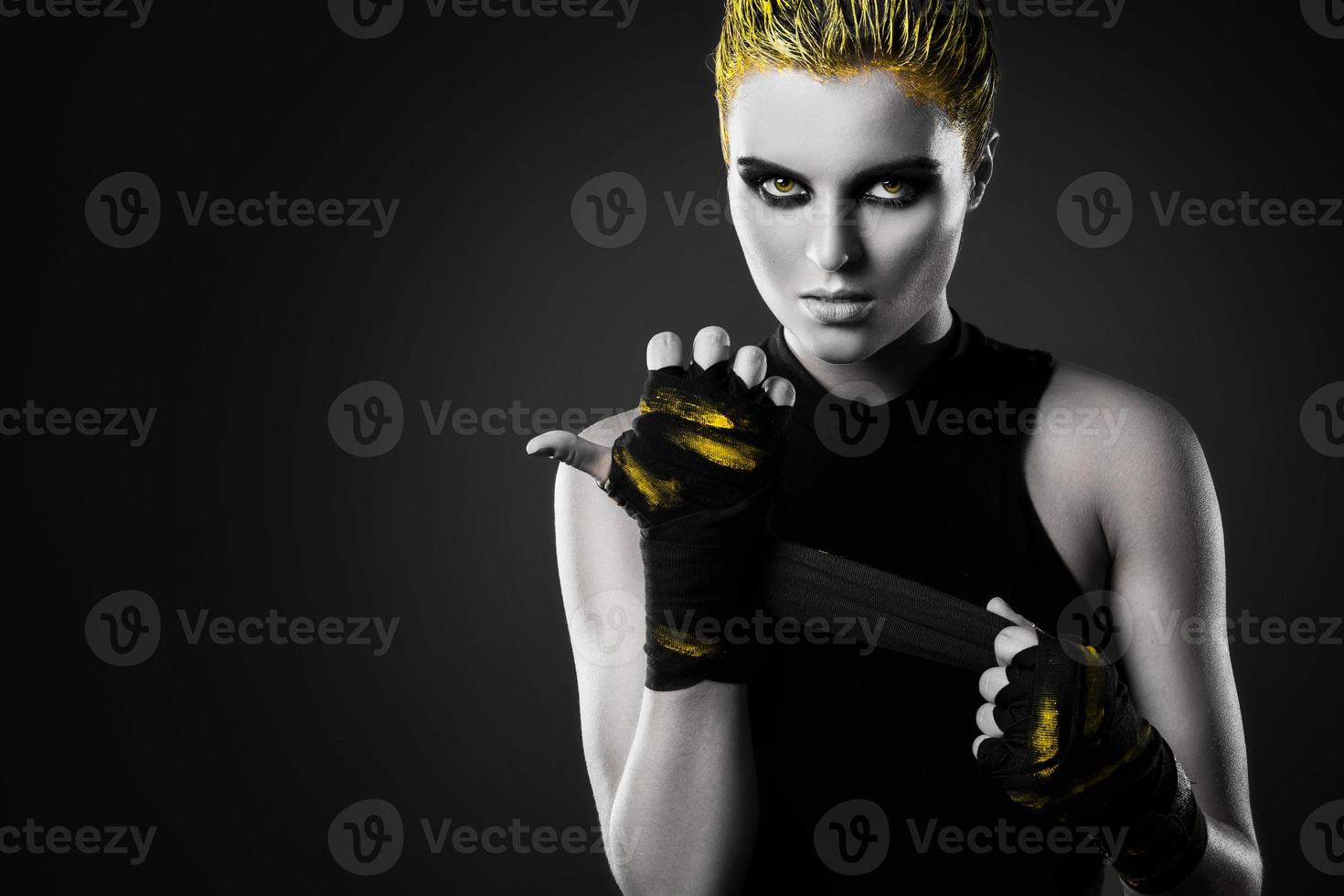 Woman mma fighter with yellow hair in studio photo