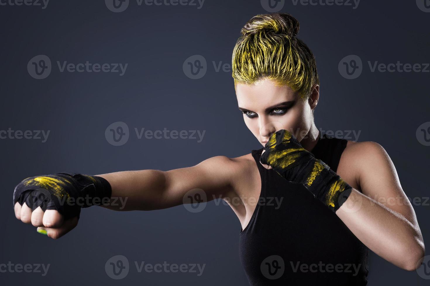 mujer luchadora de mma con cabello amarillo en estudio foto