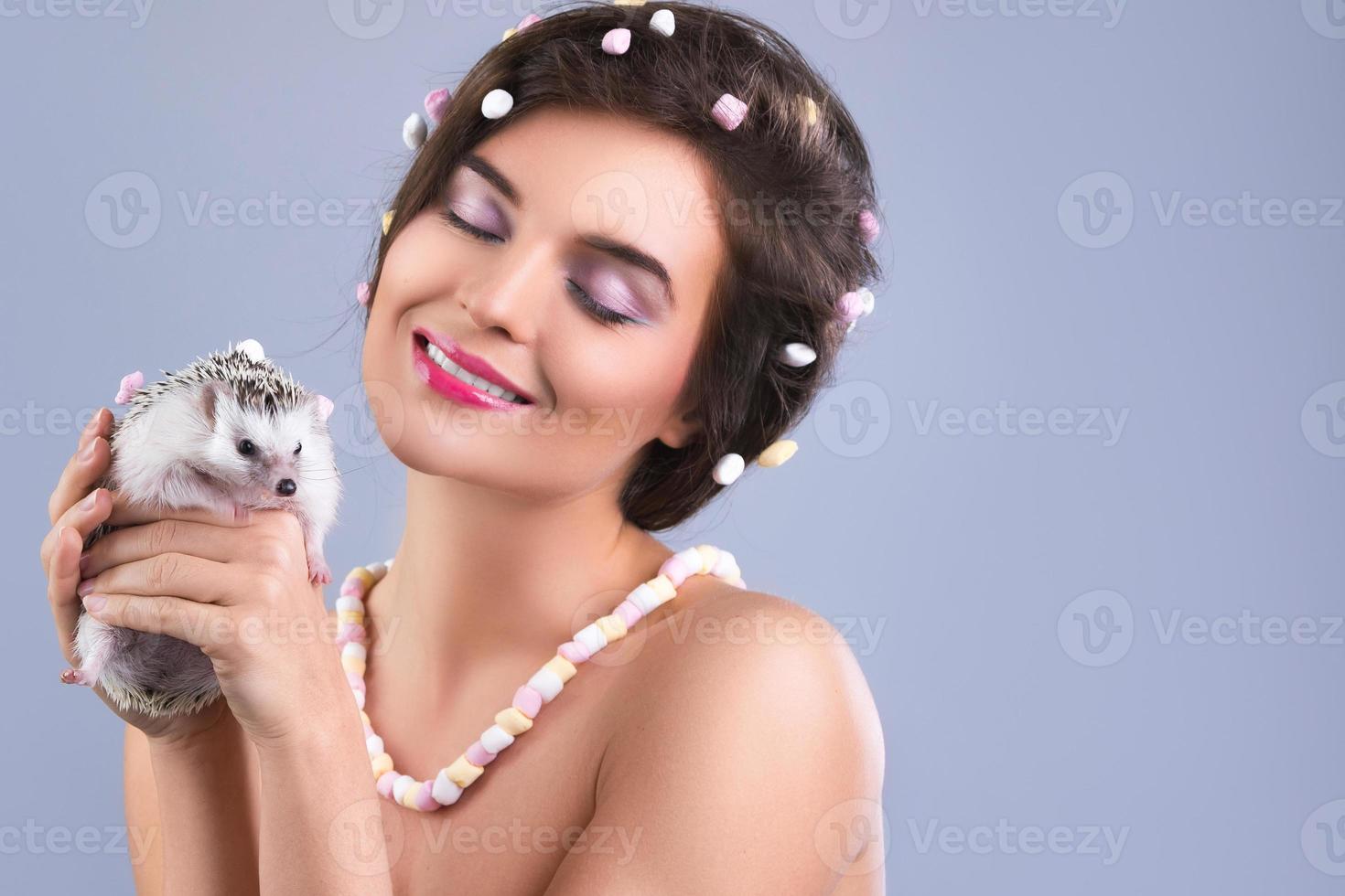 Beautiful woman is holding a cute little hedgehog photo