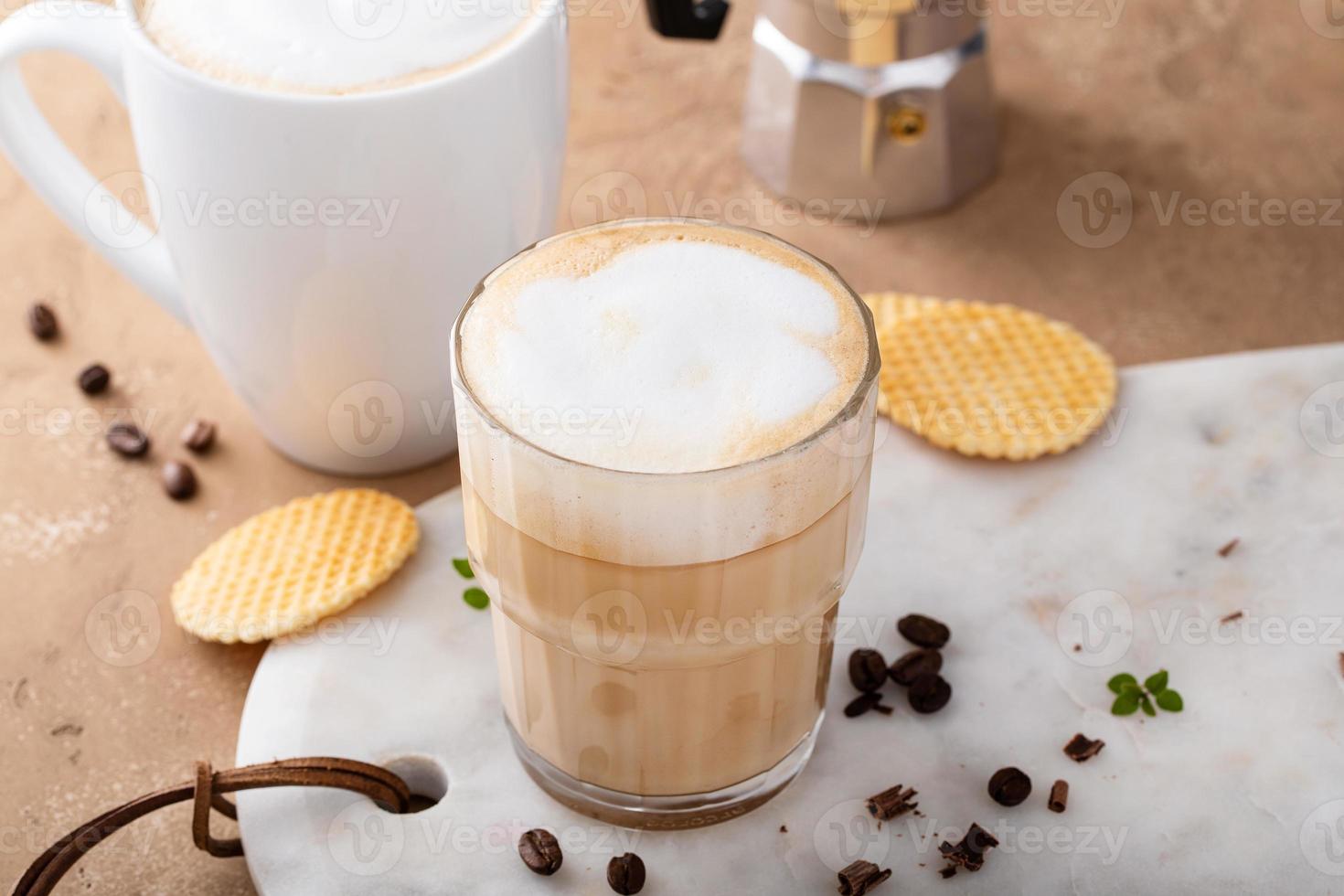 café con leche caliente y capuchino en un vaso y una taza foto