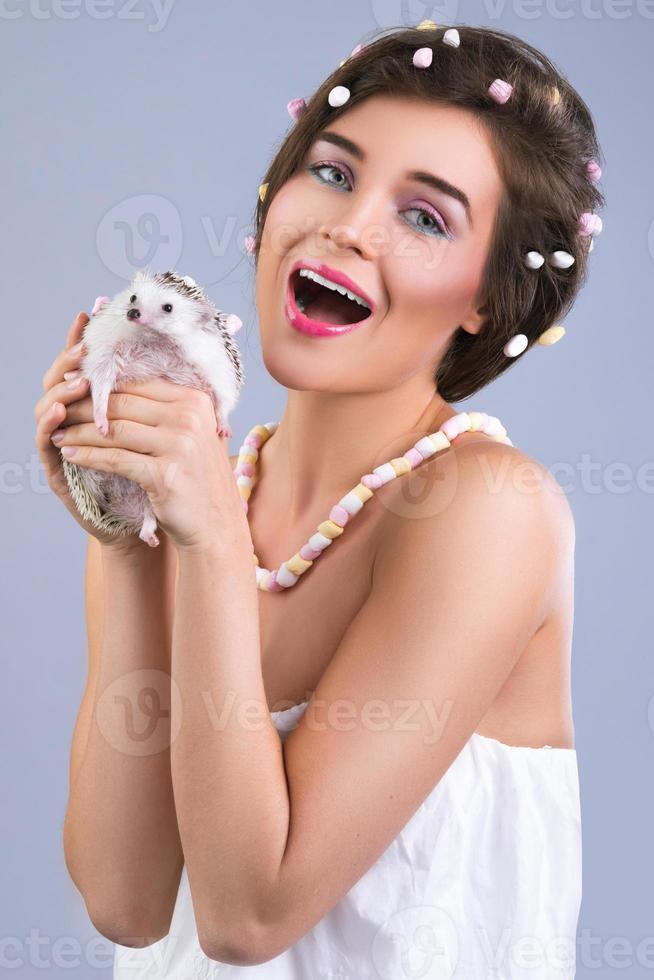 Beautiful woman is holding a cute little hedgehog photo