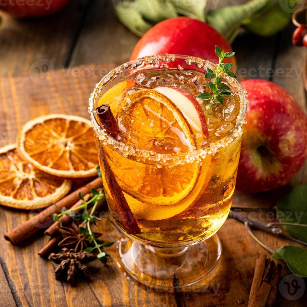 cóctel festivo de otoño o cóctel sin alcohol con sidra dura, manzana y naranja foto