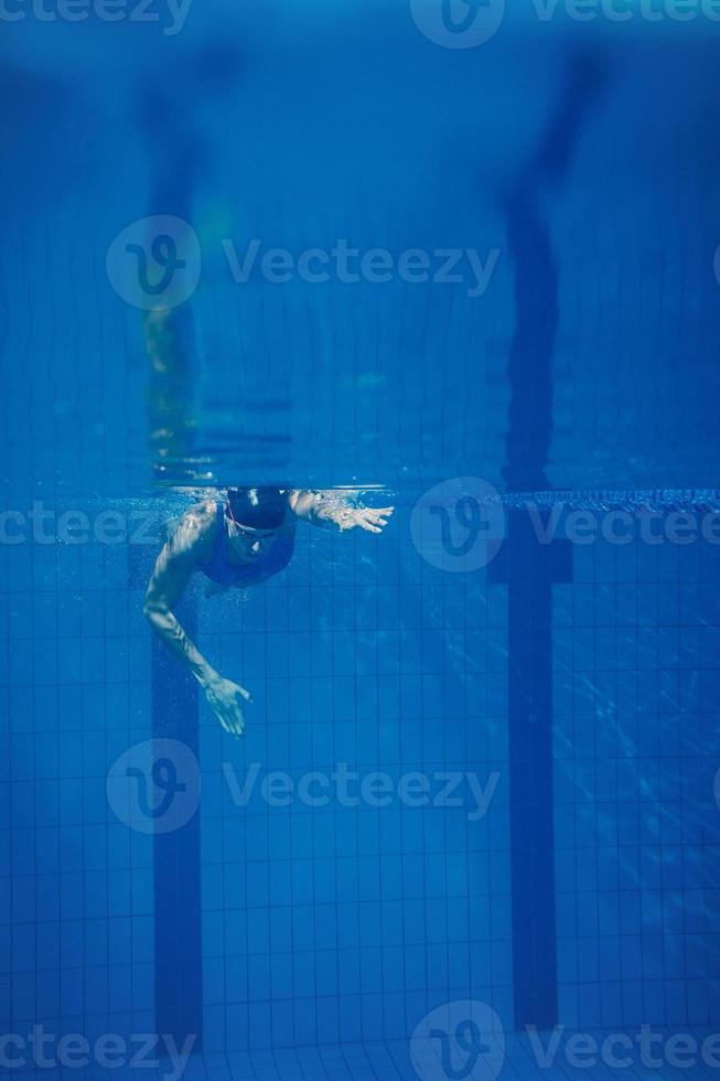 mujer nadadora bajo el agua durante su entrenamiento en la piscina foto