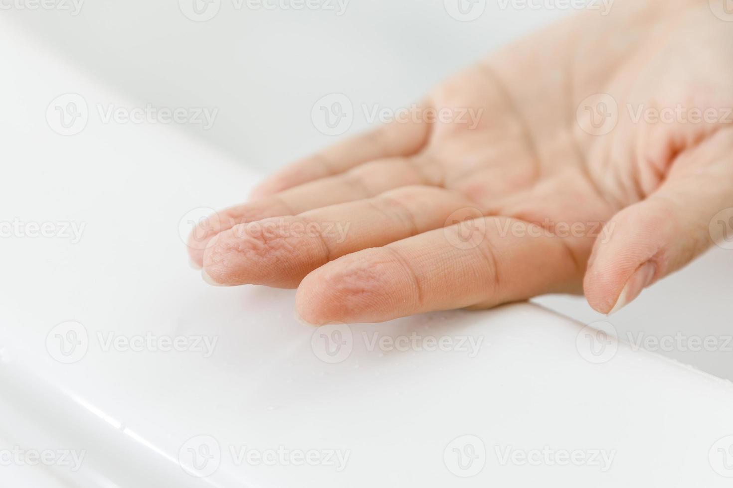 primer plano de la mano femenina con arrugas después del baño foto