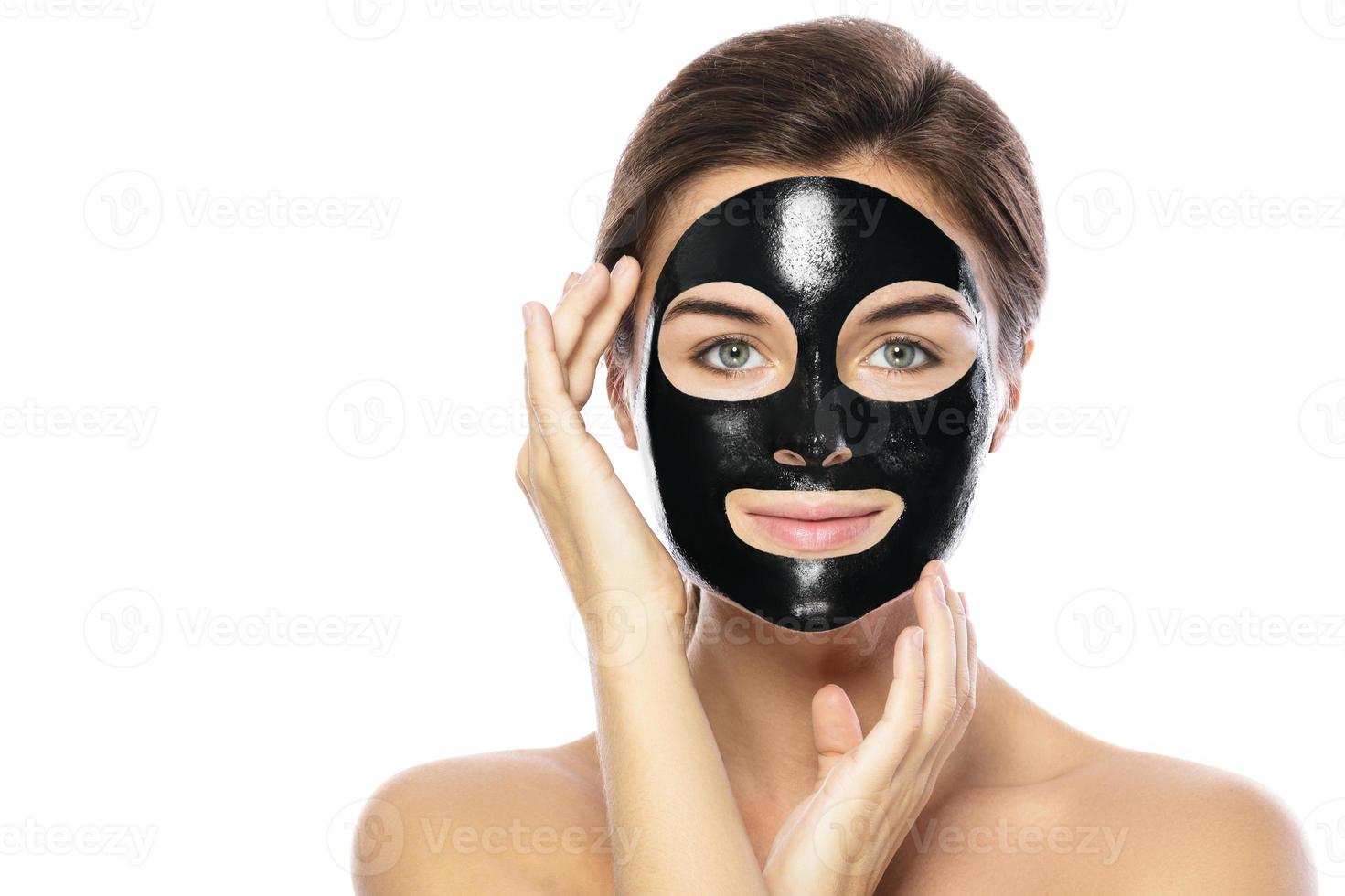 Woman with purifying black mask on her face photo