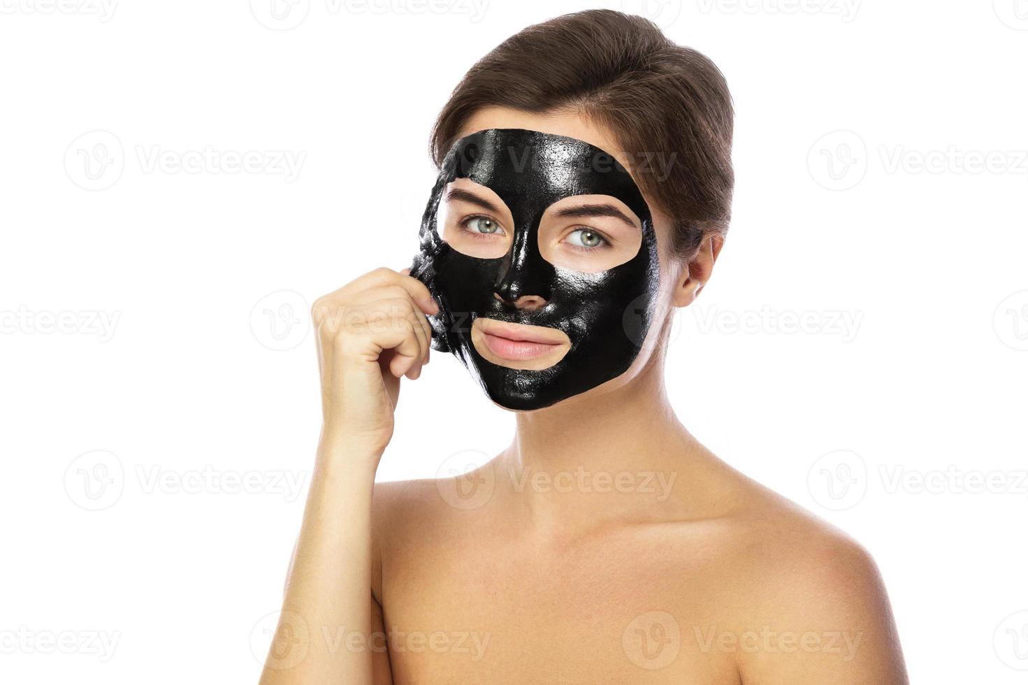 Woman with purifying black mask on her face photo