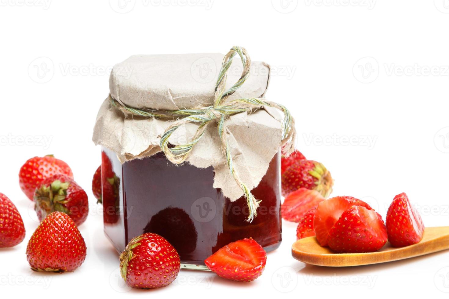 Jar of jam and strawberries on white background photo