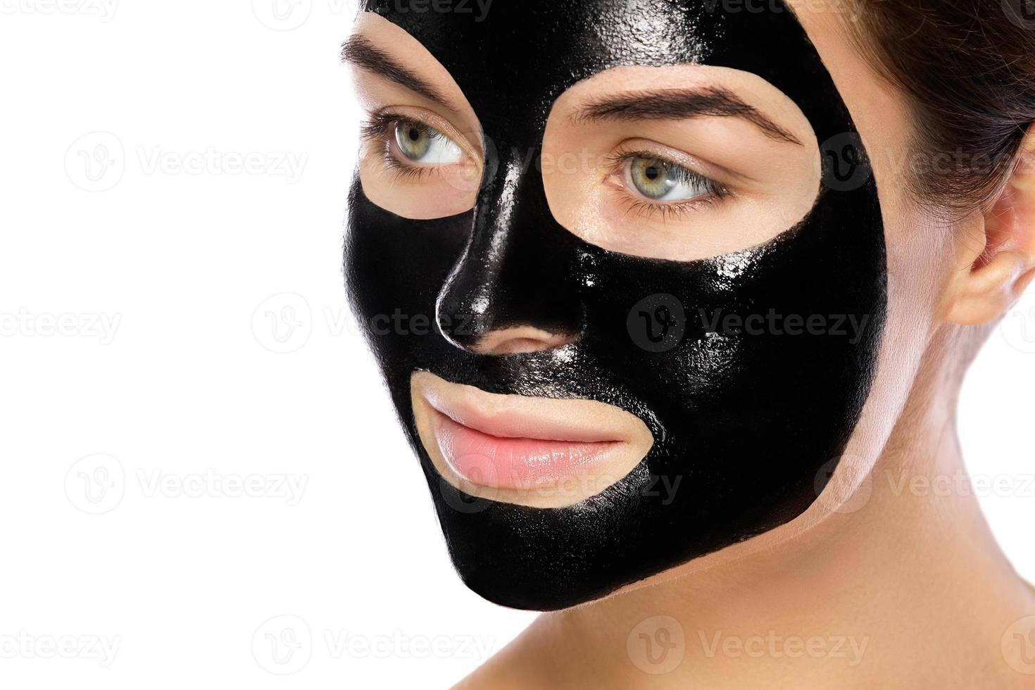 Woman with purifying black mask on her face photo