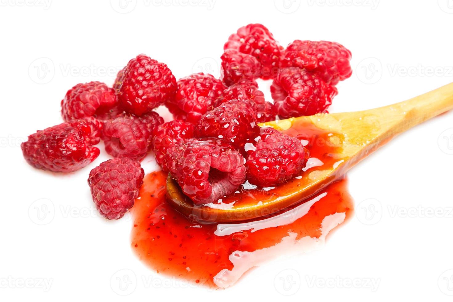 Raspberries and jam in the spoon on white background photo