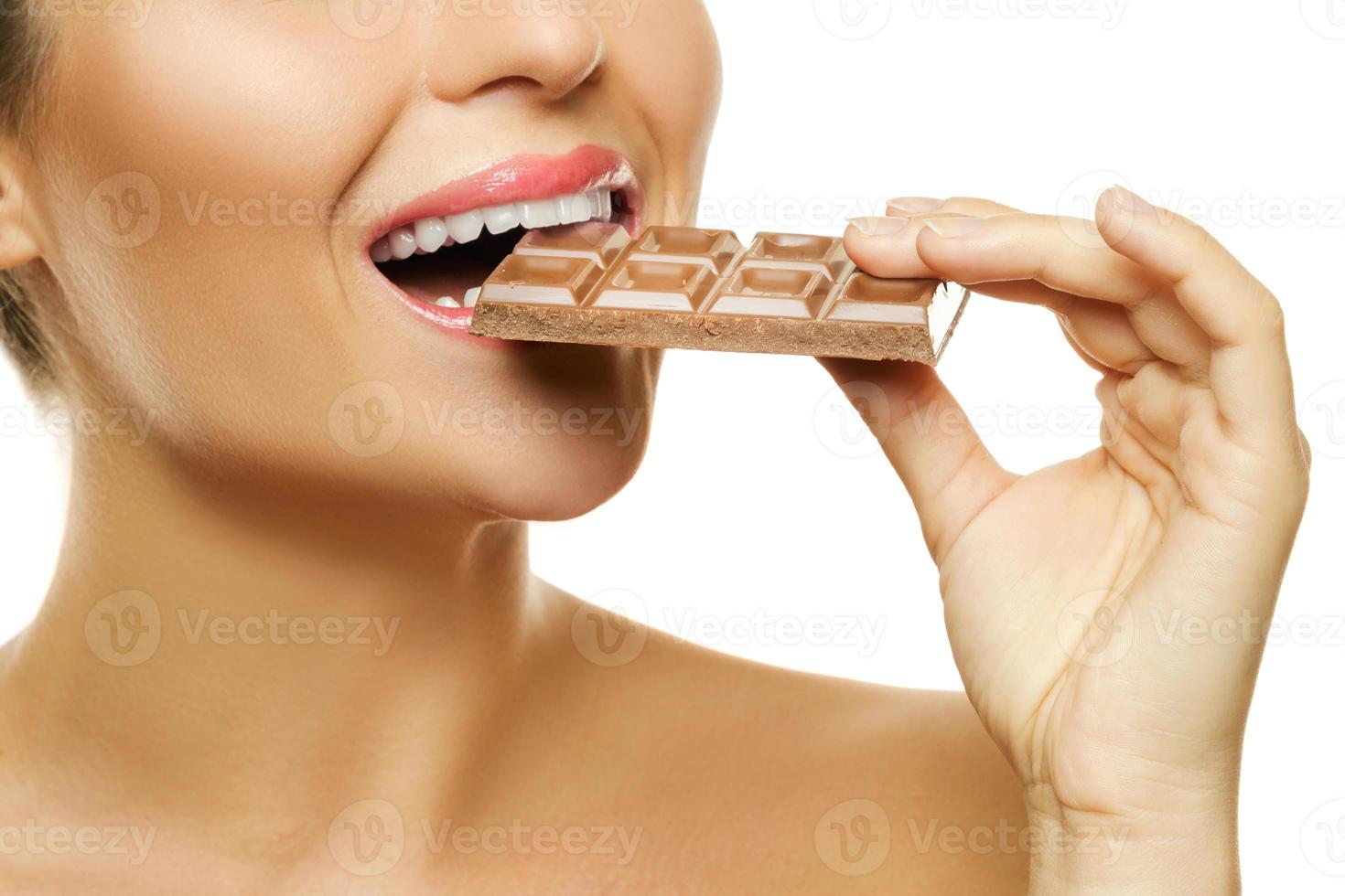 Female mouth and chocolate bar on white photo