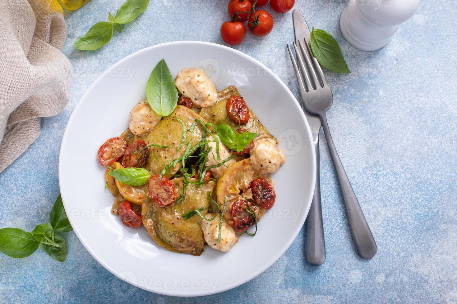 Ravioli with basil, tomatoes and mozzarella in tomato sauce photo