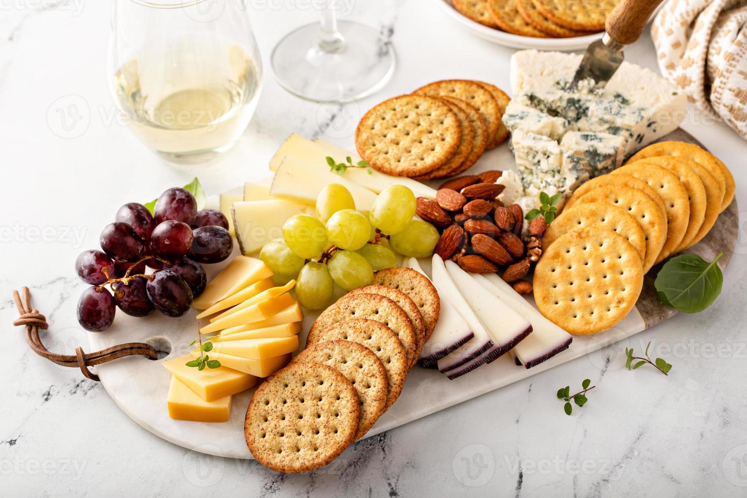 Cheese board with crackers, nuts and grapes photo