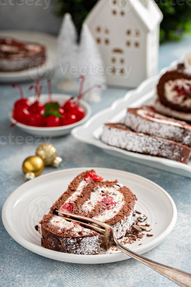 rollo de pastel selva negra con crema batida y cerezas foto