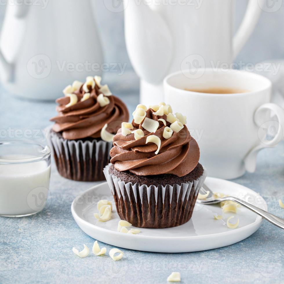 Dark chocolate cupcakes with whipped ganache frosting and white chocolate curls photo