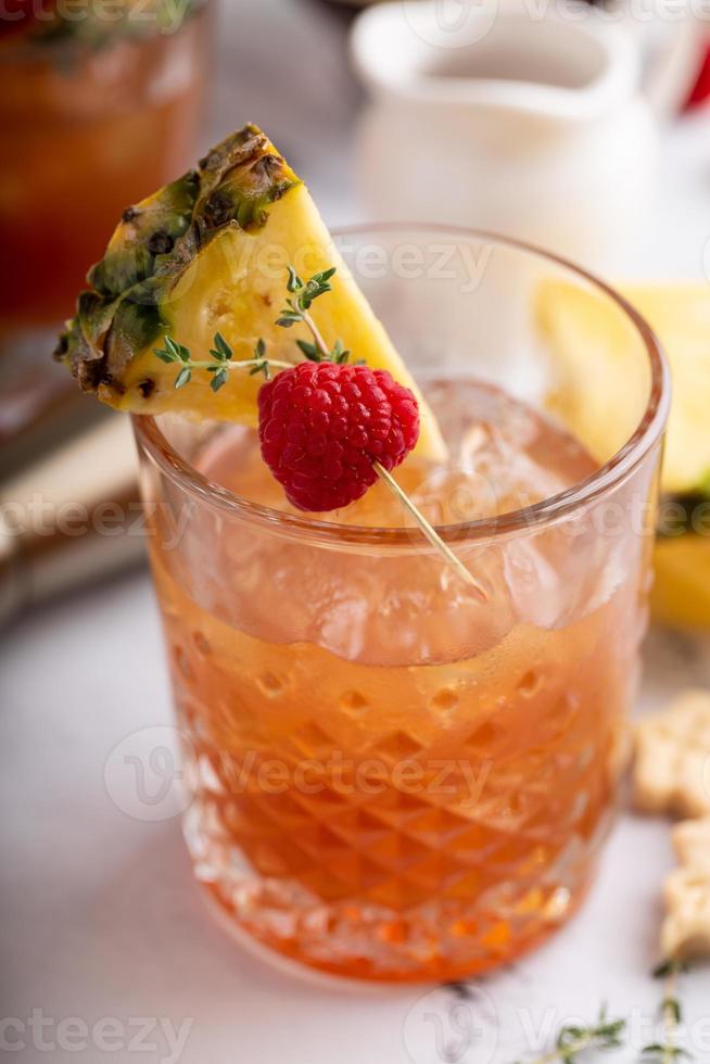 Raspberry pineapple refreshing cocktail with thyme sprig photo