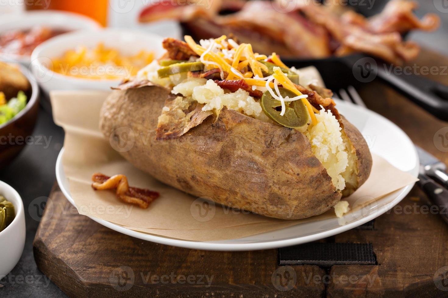 papa al horno completamente cargada con todos los ingredientes foto