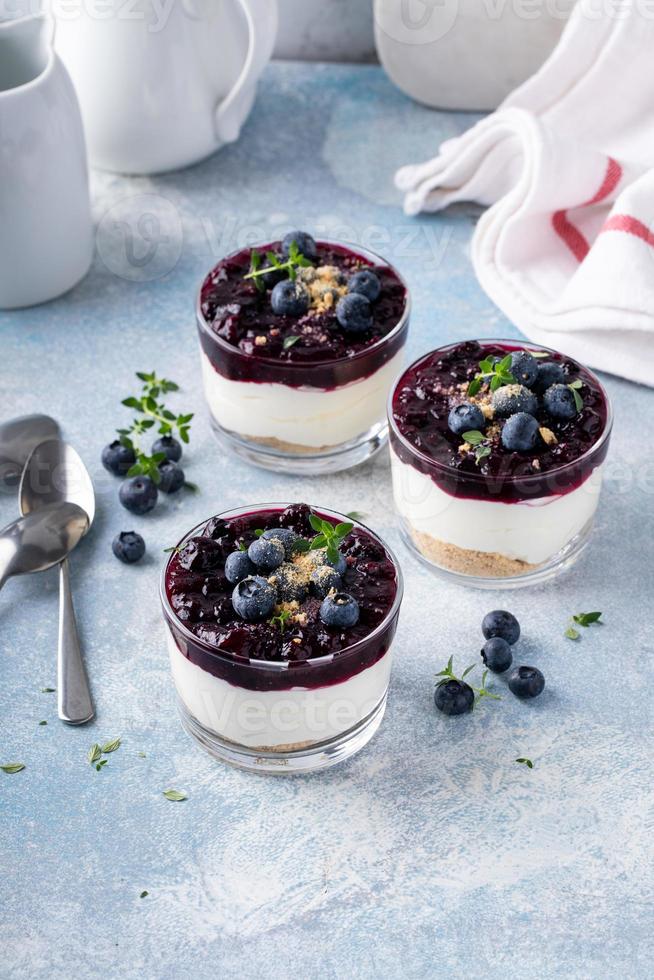 Blueberry cheesecake in a jar with graham cracker base photo