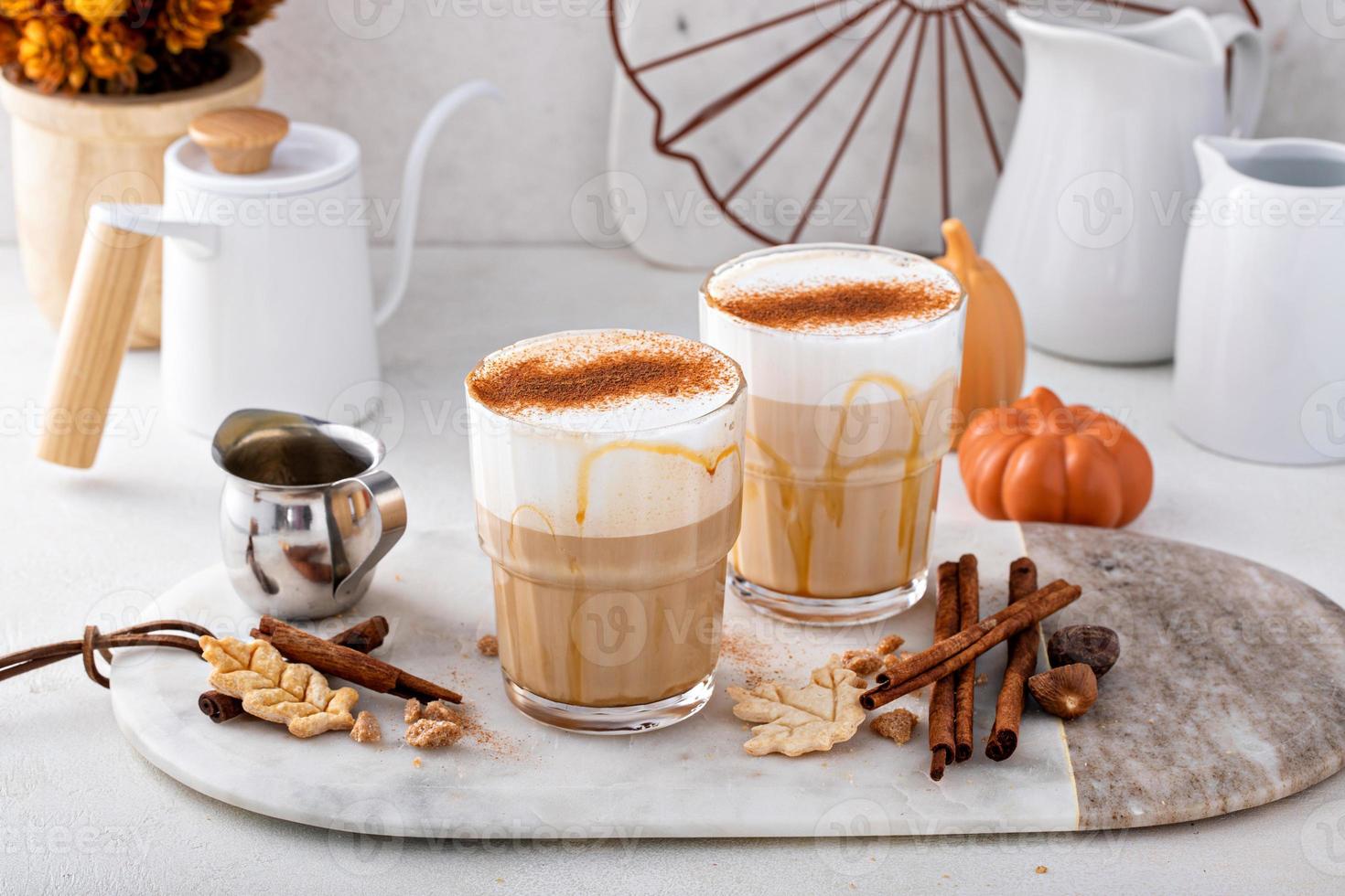 Latte de especias de calabaza cubierto con espuma de leche y espolvoreado con canela foto