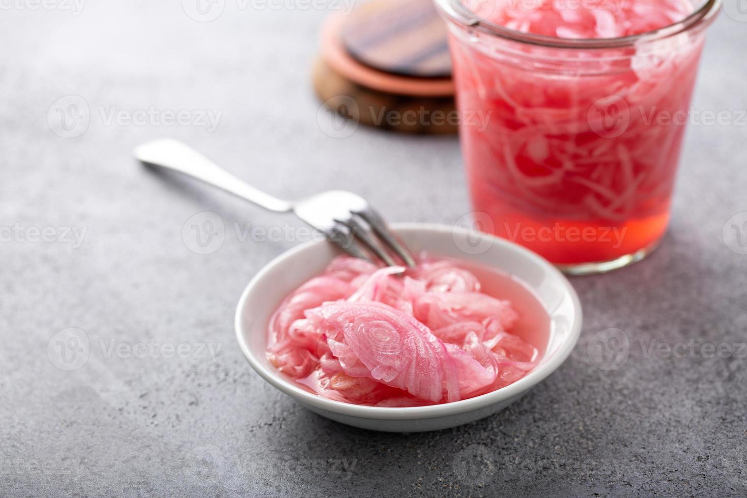 Marinated red onion in small bowl photo