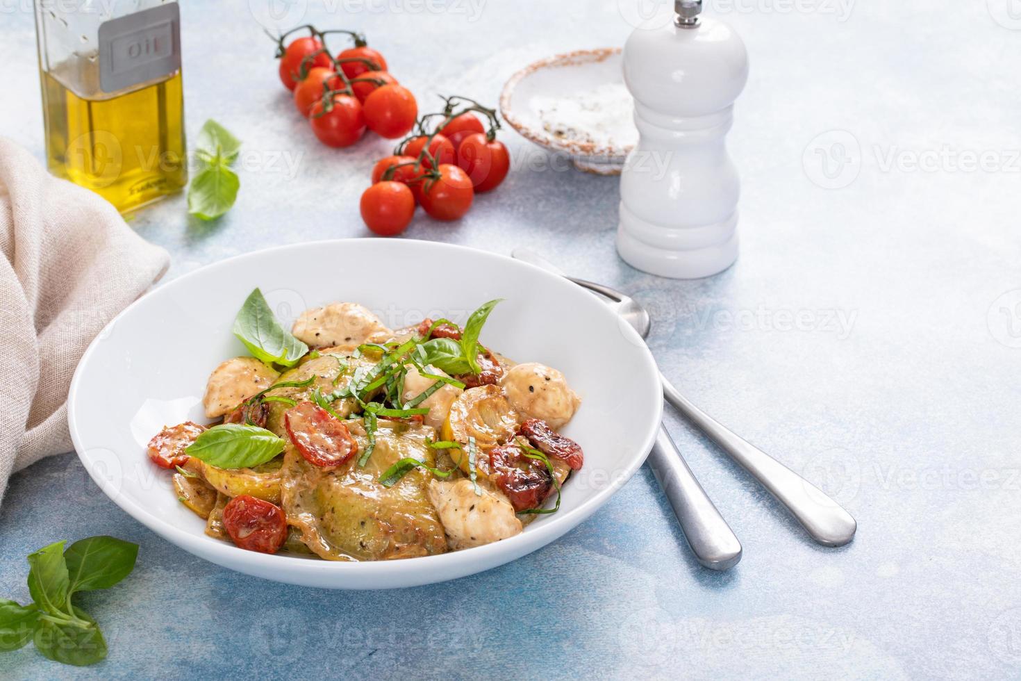 Ravioli with basil, tomatoes and mozzarella in tomato sauce photo