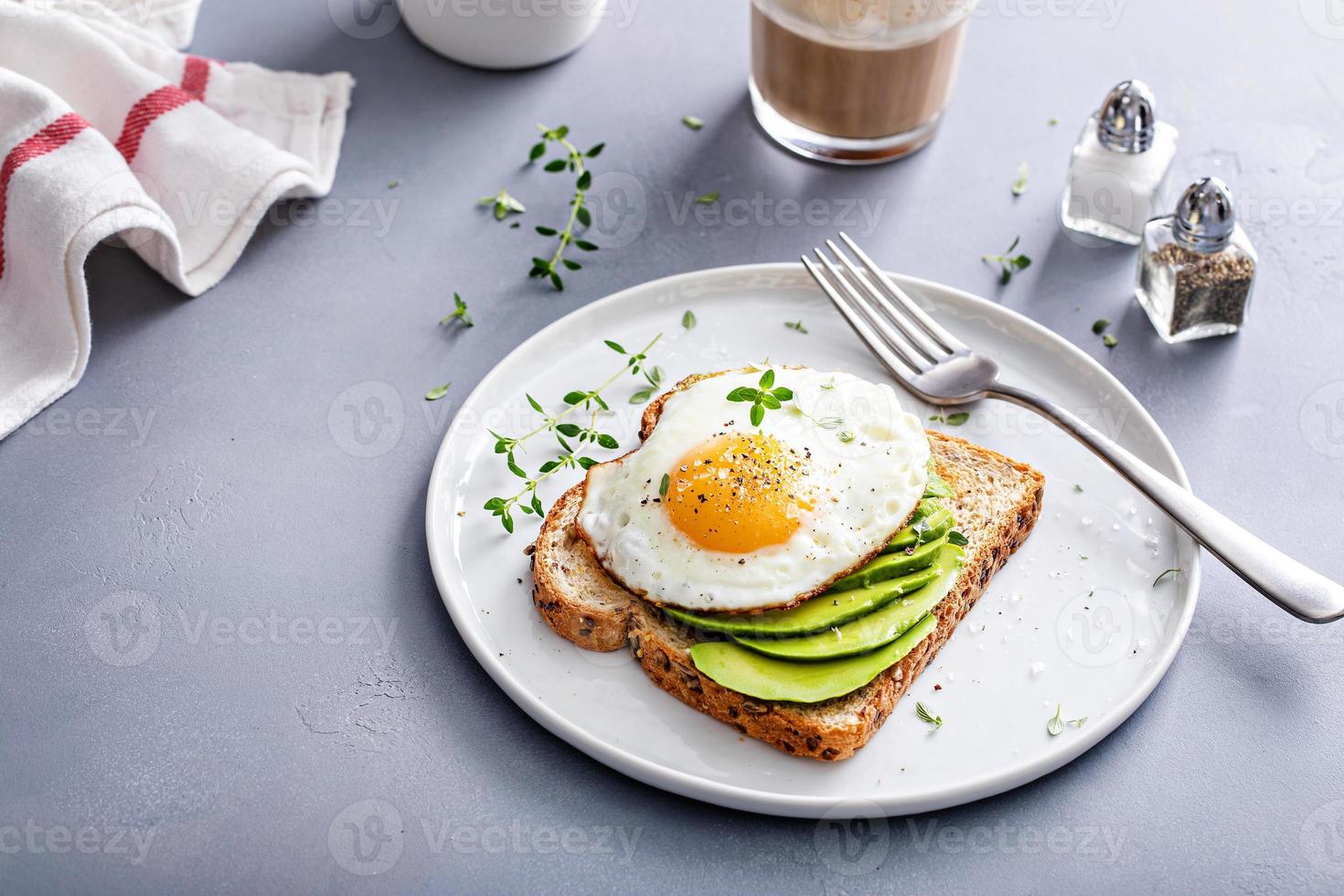 Avocado toast on a toasted multigrain bread with a fried egg photo