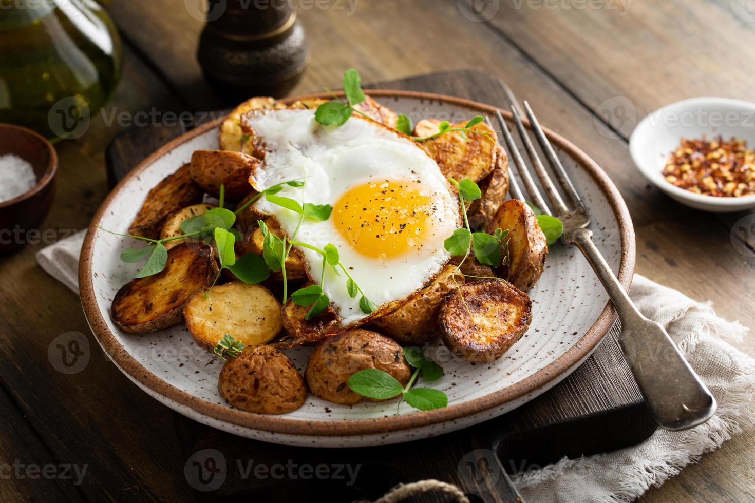 Rustic roasted potatoes with fried egg for breakfast photo