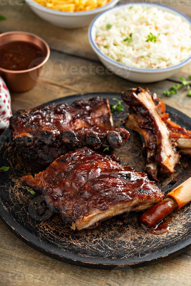 costillas asadas a la parrilla con salsa bbq y guarniciones foto