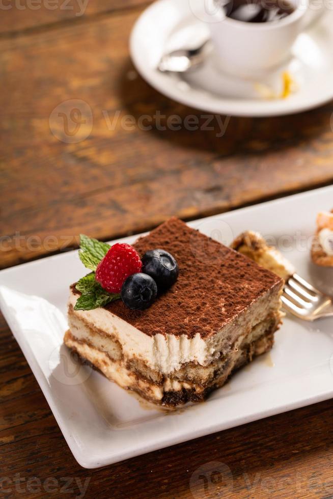 Traditional italian desserts, tiramisu and cannoli on the plate photo