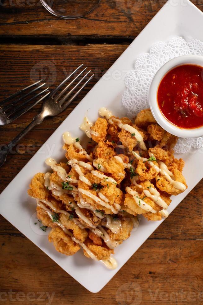 Fried shrimp appetizer served with tomato sauce photo