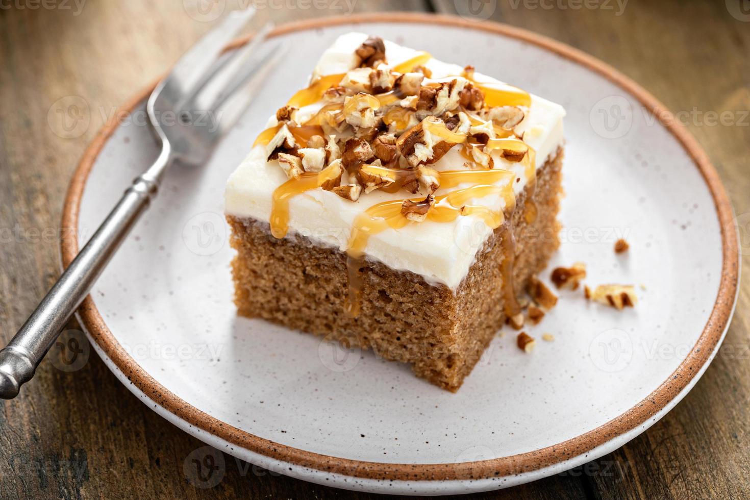 Carrot or pumpkin spiced cake with cream cheese frosting and pecan photo