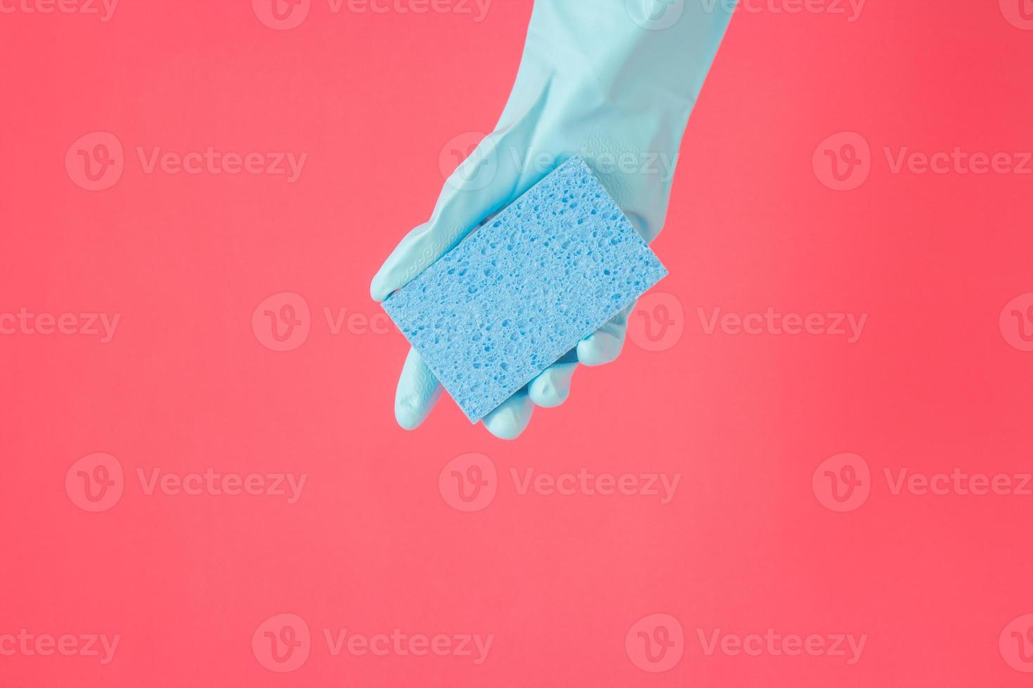 concepto más limpio, mano en guantes de goma y esponja azul claro para limpiar en casa foto