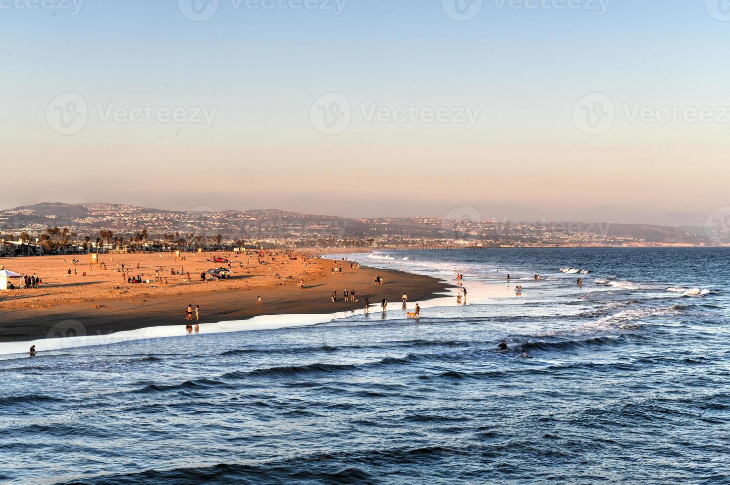 Waves in the Pacific Ocean and view of the beach at sunset, in Newport Beach, California. photo