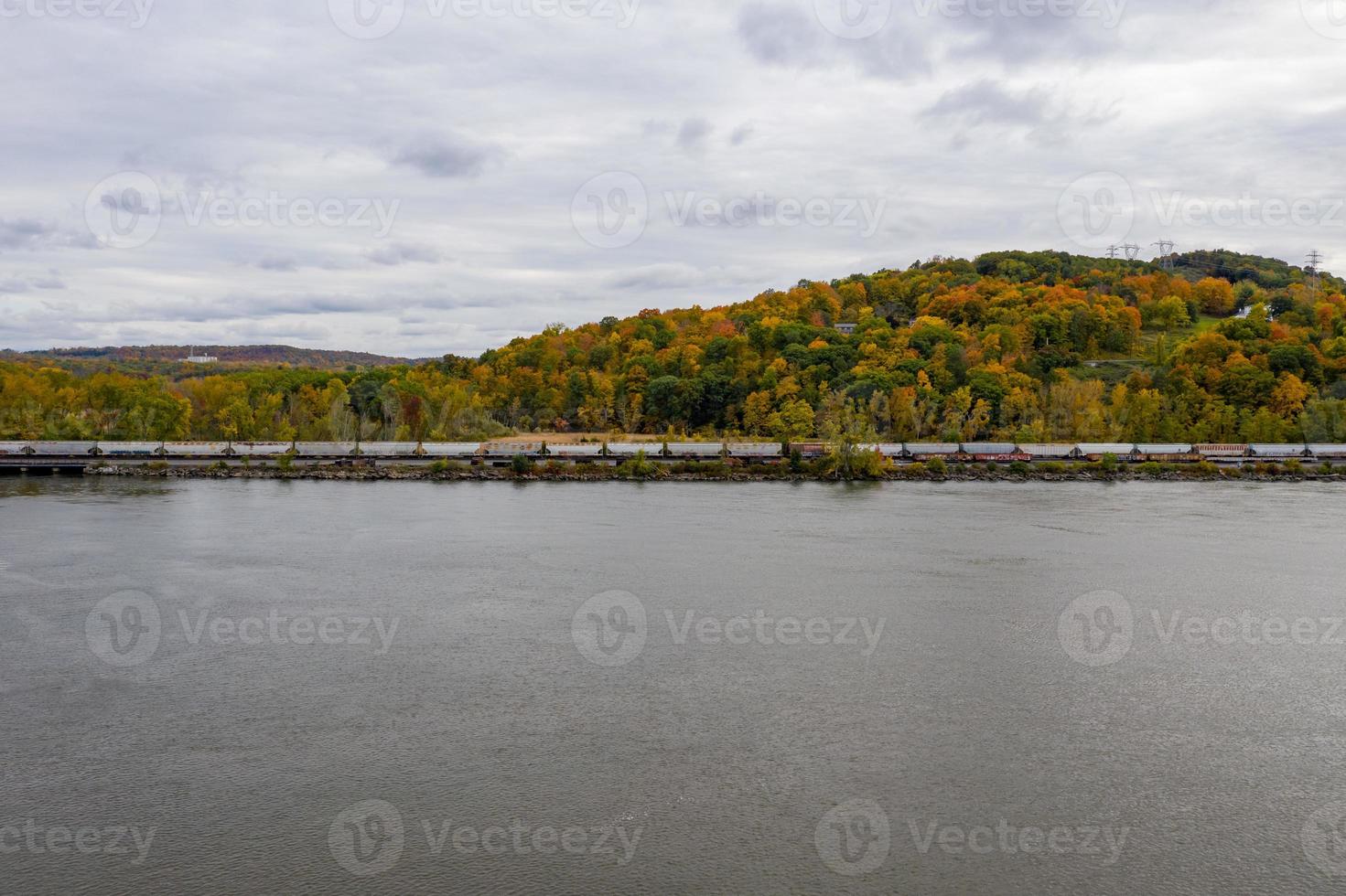 Train riding up the Hudson River in New York State with a background of fall foliage. photo