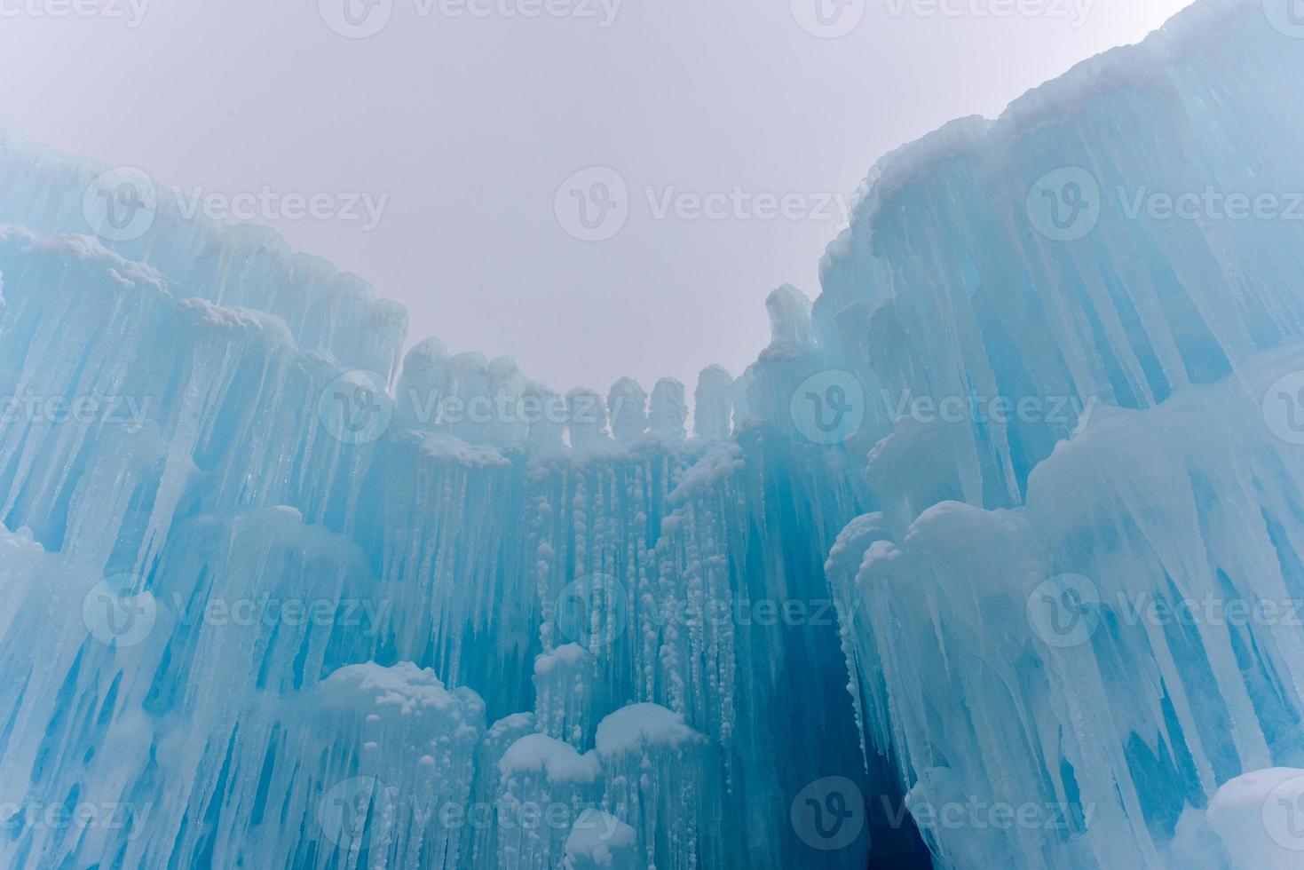 Translucent blue icicles in a frozen ice wall. photo