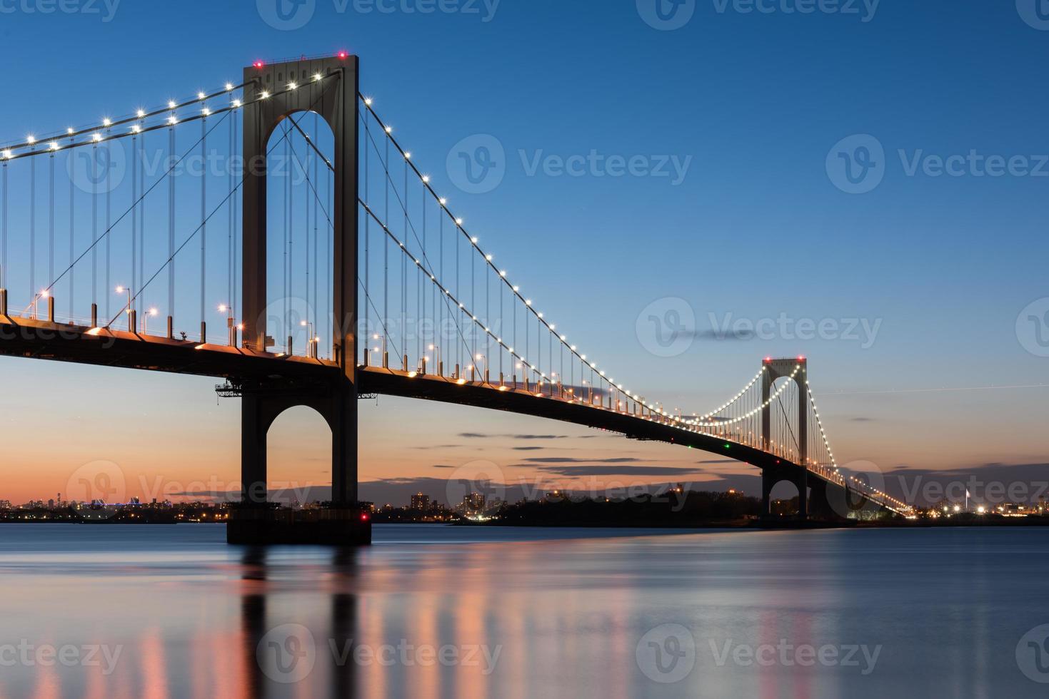 The Bronx-Whitestone Bridge reflecting on the East River at night in New York. photo