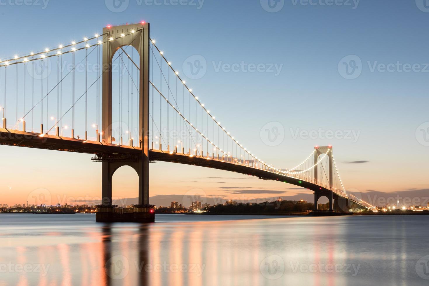 The Bronx-Whitestone Bridge reflecting on the East River at night in New York. photo