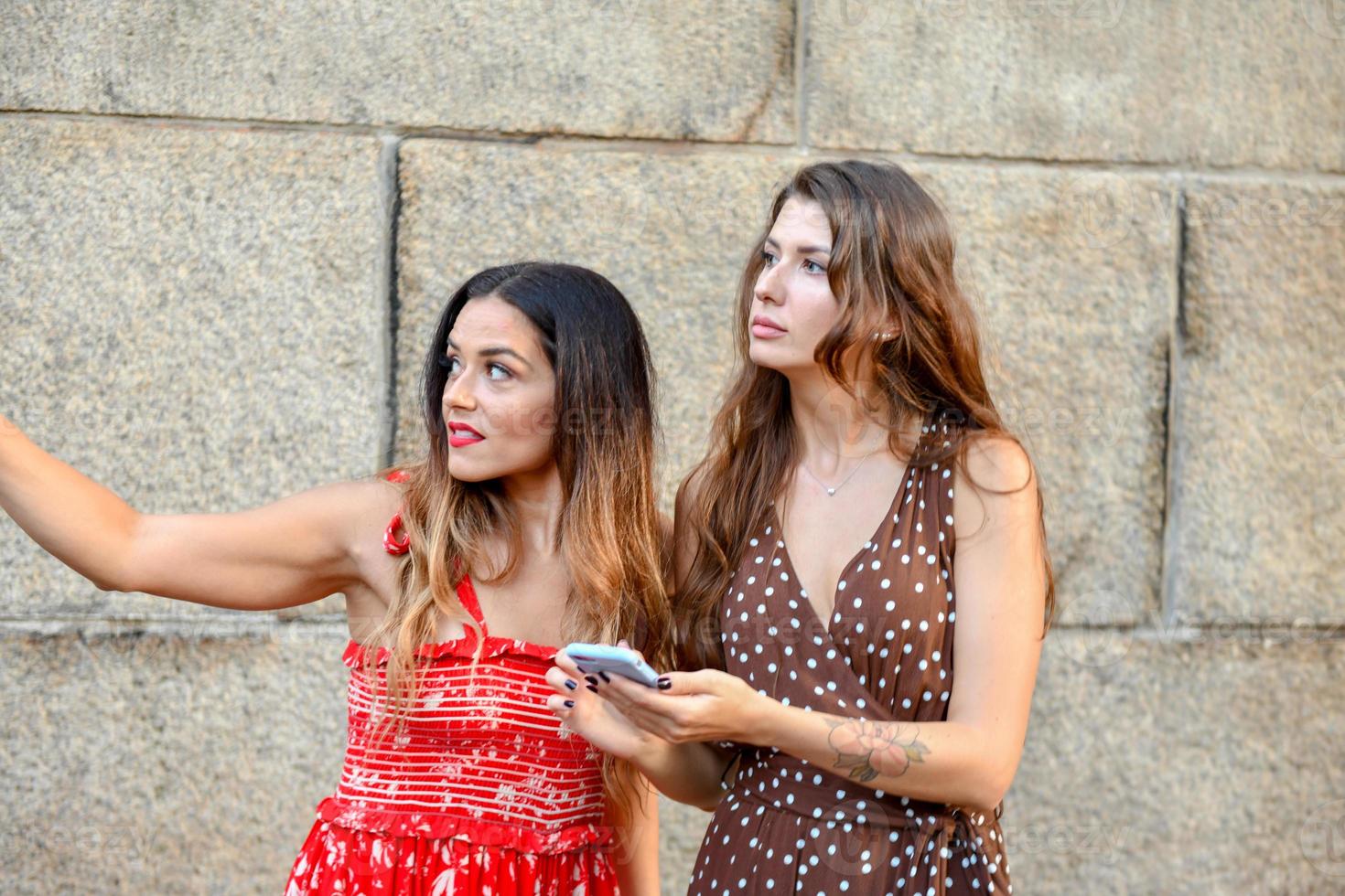 Two lost girls interacting with a mobile phone to get directions in New York City photo