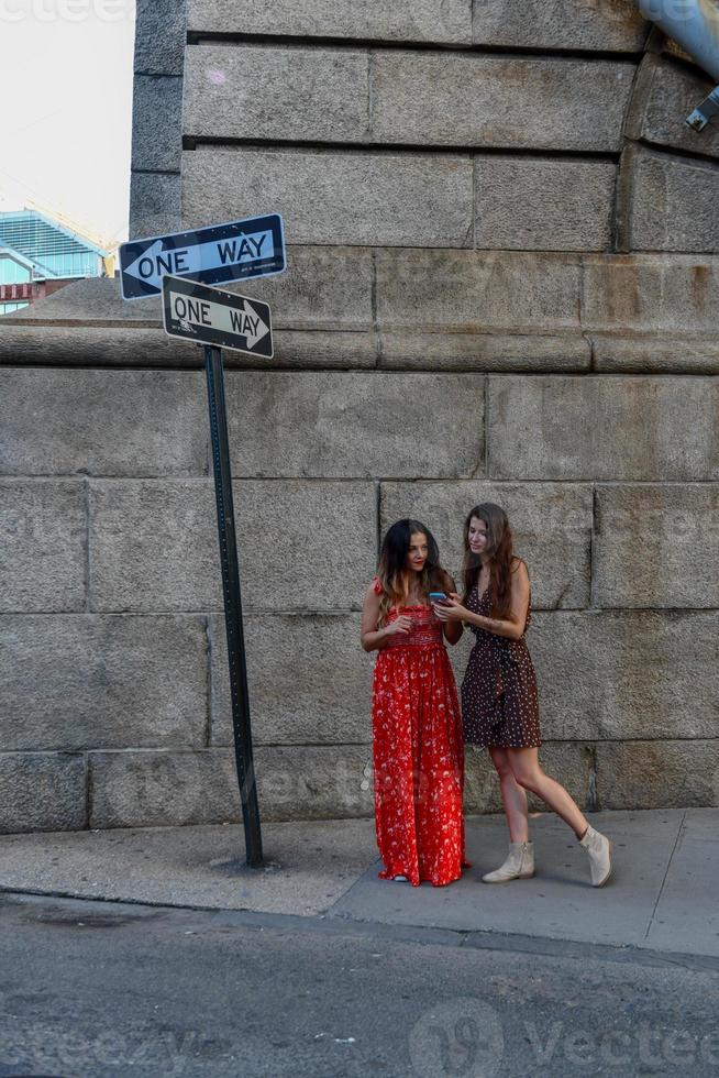dos chicas perdidas interactuando con un teléfono móvil para obtener direcciones en la ciudad de nueva york foto
