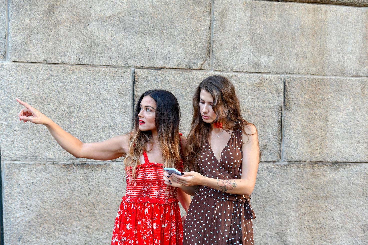 Two lost girls interacting with a mobile phone to get directions in New York City photo