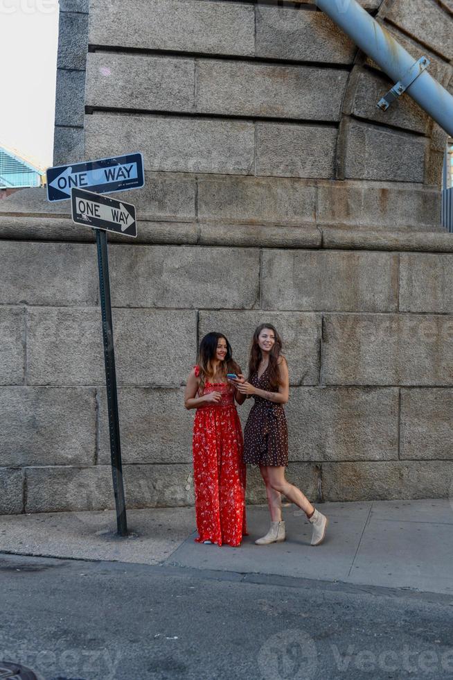 dos chicas perdidas interactuando con un teléfono móvil para obtener direcciones en la ciudad de nueva york foto