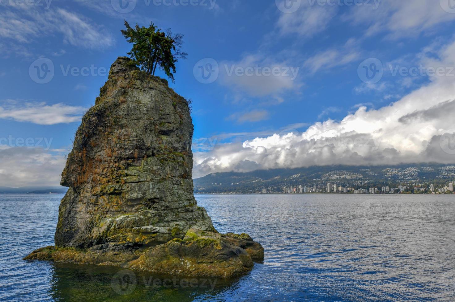 Siwash Rock, also known by Squamish name Skaish, a famous rock outcropping formation on Stanley Park Seawall Vancouver British Columbia Canada photo