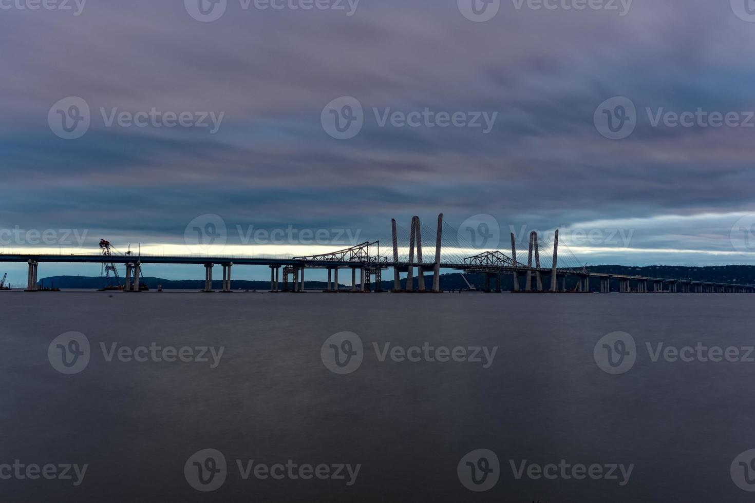 New and Old Tappan Zee Bridges coexisting across Hudson River with a dramatic sunset. photo