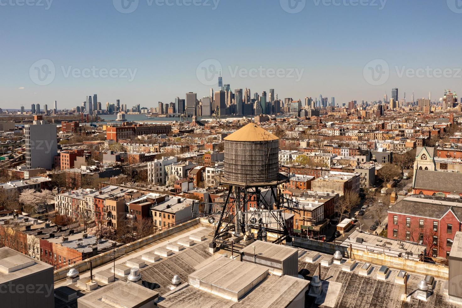 Brooklyn, New York - Apr 8, 2021 -  Water tower and a view of the Manhattan Skyline in the background. photo