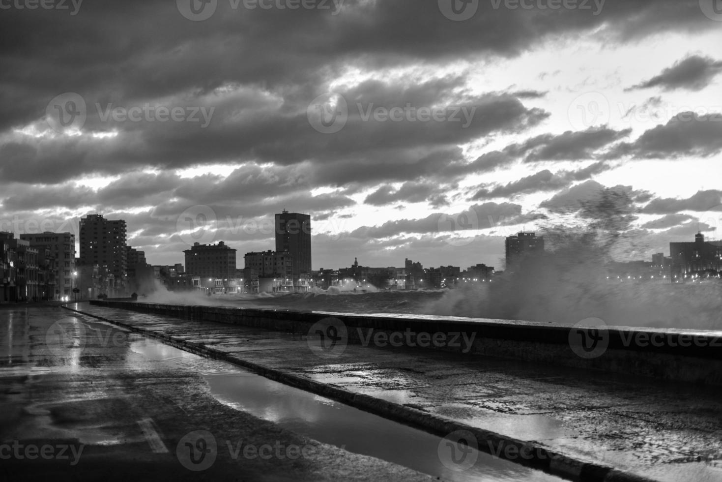 Evening at the seaside drive Malecon in Havana, Cuba as the waves crash over. photo