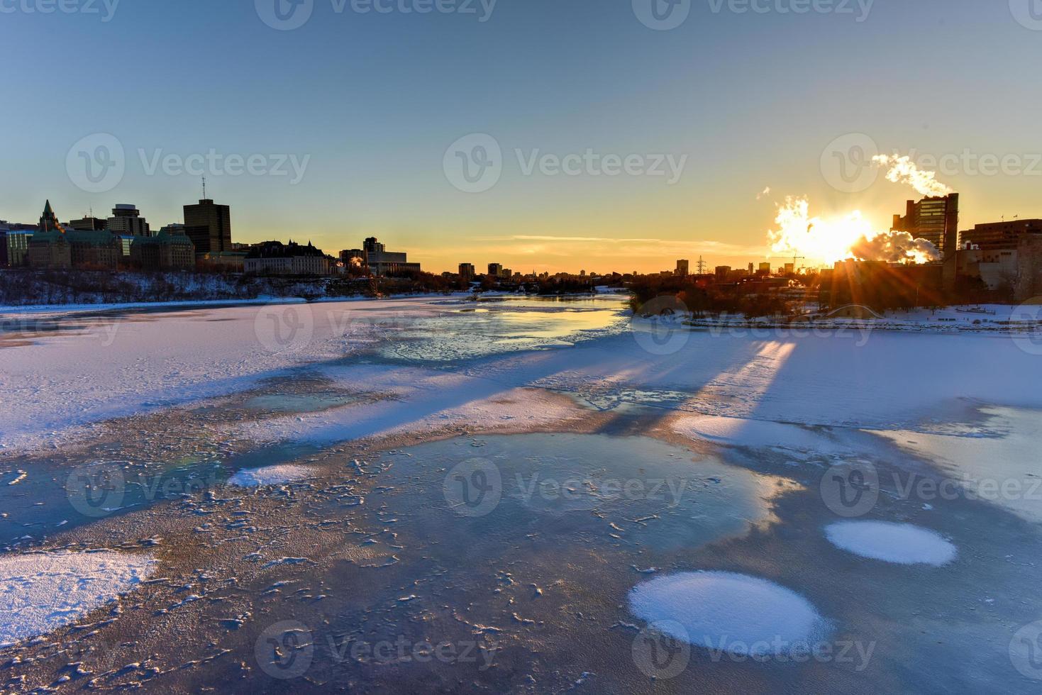 Parliament Hill and the Canadian House of Parliament in Ottawa, Canada across the frozen Ottawa River during wintertime. photo