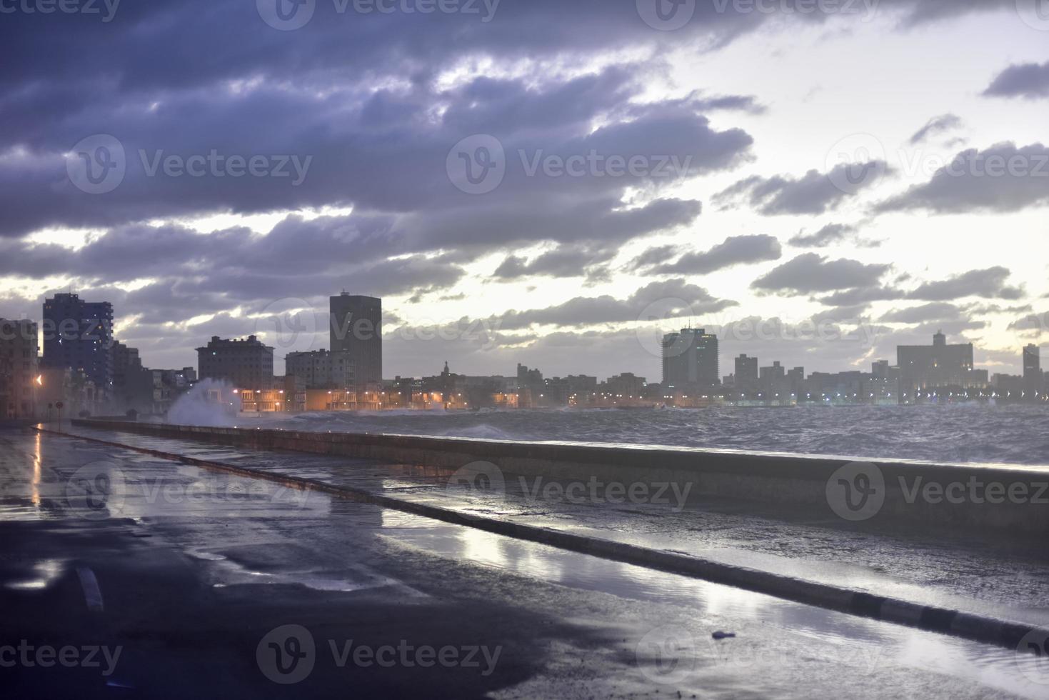 por la noche en el malecón de seaside drive en la habana, cuba, mientras las olas rompen. foto