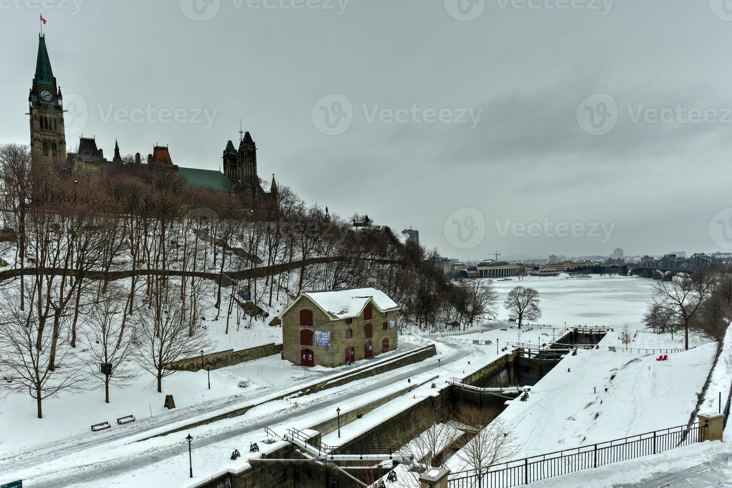 Sluice gate on Rideau Canal in winter time in Ottawa, Canada with Parliament Hill in the background. photo