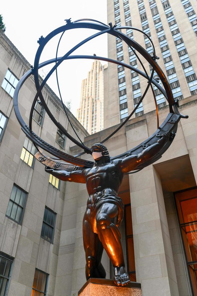 nueva york, ny - 14 de noviembre de 2020 - la firma de bienes raíces tishman speyer instaló máscaras en el atlas y otras estatuas clásicas en el centro rockefeller para alentar a los neoyorquinos a usar cubiertas faciales covid-19. foto