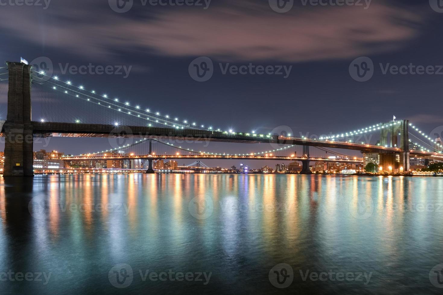 View of the Brooklyn, Manhattan and Williamsburg Bridge at night from South Street Seaport, New York City. photo